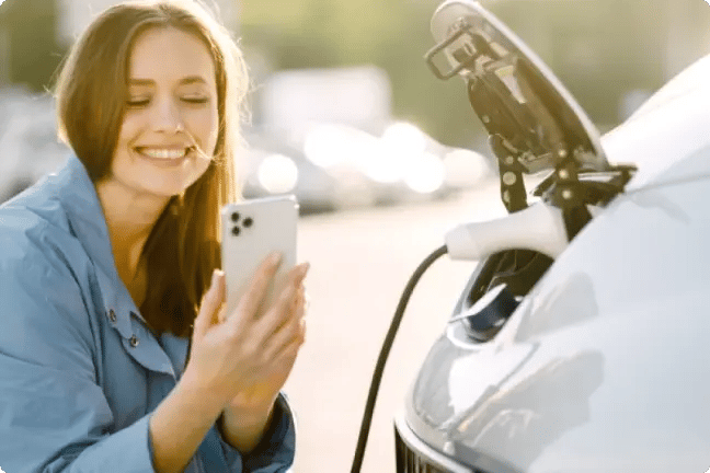 Woman photographing electric vehicle